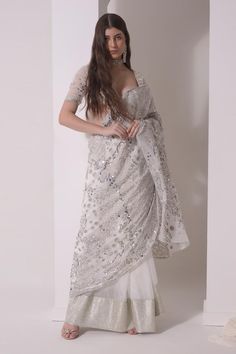 White saree with all over abstract foil printed and gota wave embellishments. Paired with elbow sleeves padded blouse with tonal sequin and sweetheart neckline.
Components: 2
Pattern: Print, Embellished
Type Of Work: Foil, Sequin
Neckline: Queen Anne Neckline
Sleeve Type: Elbow Sleeves
Fabric: Organza
Color: White
Other Details: 
Padded blouse
Weight: 5-7kgs
Model Height: 5ft 9inches, wearing size S
Note: The outfit worn by the other model is not for sale
Occasion: Destination Wedding, Cocktail Unstitched Embellished Blouse Piece For Wedding, Unstitched Embellished Wedding Blouse Piece, Wedding Embellished Unstitched Blouse Piece, Mirror Work Blouse For Eid Wedding, Transitional Wedding Blouse With Mirror Work, Wedding Embellished Chanderi Blouse Piece, Wedding Blouse With Sheer Dupatta For Diwali, Embellished Blouse For Wedding And Eid, Eid Wedding Embellished Pre-draped Saree