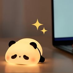 a panda bear lamp sitting on top of a desk next to a laptop computer and mouse