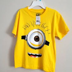 a yellow t - shirt with an image of a minion on it's chest