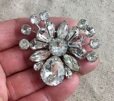 "You will receive this stunning antique Eisenberg rhinestone brooch. It is signed with the block E, which dates it between 1942-1945. It measures 2\" x 1 3/4\" and is in very good vintage condition with sparkling rhinestones and no tarnish to the metal. The safety catch is functioning properly and secure. This piece is fascinating and almost looks like a butterfly. Truly a must have for the Eisenberg collector. For finished vintage assemblage and vintage inspired jewelry, and select signed piece Vintage Crystal Brooches For Anniversary, Vintage Anniversary Brooch With Sparkling Stones, Vintage Silver Brooches With Sparkling Stones, E Signature, Brooch Art, Like A Butterfly, Vintage Assemblage, Vintage Inspired Jewelry, Pretty Beads