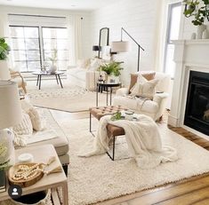 a living room filled with white furniture and lots of pillows on top of it's rug