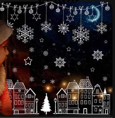 a child looking out the window at snowflakes and christmas lights in the night sky