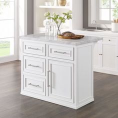 a white kitchen island sitting in the middle of a room