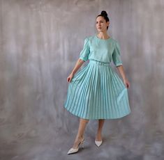 80s green midi dress with a pleated skirt, satin dress for a wedding guest, pearl buttons vintage tea dress or garden party dress - size M.  Super chic, elegant and classy midi dress made of a silky satin fabric in a aqua green color. Beatiful pleated skirt and maching belt.  ⊁ Color: aqua green, pale green. The backgound color is white but has the smallest green polka dots printed in different sizes all over the fabric, creating an all-green effect.  ⊁ The midi-length skirt boasts flattering pl Spring Wedding Tea Length Dress With Pleated Bodice, Spring Party Vintage Pleated Dress, 1950s Style Formal Midi Dress, Spring A-line Vintage Dress For Cocktail, Fitted Pleated Dress With Box Pleat For Spring, Spring A-line Vintage Cocktail Dress, Spring Cocktail Vintage A-line Dress, Spring Wedding Midi-length Pleated Dress, Wedding Pleated Tea-length Dresses