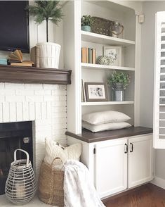 a living room with a fire place and bookshelves on the wall above it