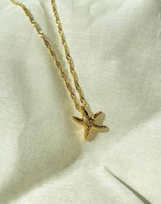 A perfect summer necklace for beach wear or resort wear with handmade metal starfish on 1 micron gold plated (18k) stainless steel (which is allergic free and nickel free) Layer it with our other neckpieces or just wear it as a single statement piece. Gold Starfish Clavicle Chain Necklace, Gold Star Charm Necklace For Beach, Gold Charm Necklace With Star For Beach, Gold Charm Necklace With Star Charm For Beach, Beach Star Charm Necklace, Dainty Beach Necklace With Delicate Chain, Dainty Necklace With Delicate Chain For Beach, Ocean-inspired Yellow Gold Beach Jewelry, Gold Starfish Charm Necklace