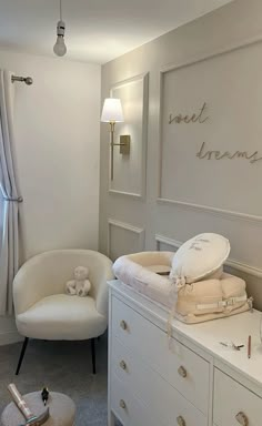 a baby's room with white furniture and decor