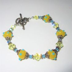 Yellow Blue Lampwork Glass bead Bracelet,  8 inch length of Blue and Yellow Cut Crystals,  Sterling Silver spacers, Artisan toggle/Ring, One of a kind Bracelet Wears like an avg size of 7.5 inches Glass Bead Bracelet, Glass Beaded Bracelets, Lampwork Glass Beads, Bead Bracelet, Glass Bead, Yellow Blue, Glass Beads, Jewelry Bracelets, Beaded Bracelets