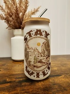 a white mason jar sitting on top of a wooden table next to a potted plant