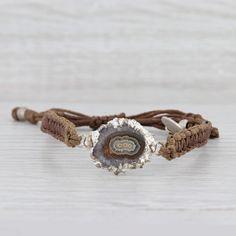 This lovely new bracelet is an authentic Nina Nguyen piece. This bracelet has a retail price of $195. Gem: Marbled Brown Geode Quartz Metal: Silver Toned Weight: 5.6 Grams  Stamps: Nina Nguyen Style: Brown woven chord with center charm Closure: Adjustable Drawstring Inner Circumference: 6"- 9 1/2" Width: 6.5 mm Charm: 16.7 x 26 mm Each piece is thoroughly examined and refinished as needed by our professional jewelers, graded by our in-house GIA (Gemological Institute of America) Graduate Gemolog Adjustable Artisan Hand Wrapped Bracelets, Bohemian Bracelet With Sliding Knot, Bohemian Sliding Knot Bracelet, Adjustable Silver Wrap Bracelet With Natural Stones, Artisan Adjustable Bangle Bracelets, Adjustable Nickel-free Spiritual Jewelry, Bohemian Bangle Jewelry With Sliding Knot, Adjustable Artisan Sterling Silver Beaded Bracelets, Adjustable Bohemian Sterling Silver Bangle Bracelet