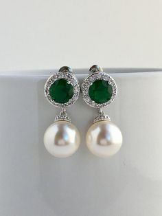 I've created this elegant green emerald cubic zirconia and pearl bridal jewelry set in rhodium plated brass setting and the set includes: # Earrings feature large 12mm Swarovski pearls that dangle from brilliant cut green emerald cubic zirconia with halo setting 12mm ear stud. Halo setting gives a brilliantly beautiful effect. Total length of the earrings is 2.8 cms. #Classic pearl bridal necklace and pendant set with rhodium plated brass peg and bail. Necklace features a pendant with large 12mm Classic Green Pearl Drop Jewelry, Green Cubic Zirconia Jewelry For Wedding, Elegant White Emerald Jewelry, Green Cubic Zirconia Wedding Jewelry, Green Pearl Drop Wedding Jewelry, Green Pearl Drop Jewelry For Wedding, Elegant Green Sterling Silver Bridal Earrings, Elegant Emerald Bridal Earrings For Anniversary, Green Bridal Earrings For Anniversary