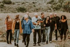 a group of people walking down a dirt road