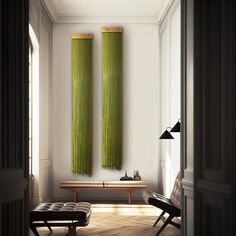 two green curtains hanging from the ceiling in a room with wooden flooring and white walls