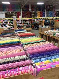 many different colored fabrics on display in a store