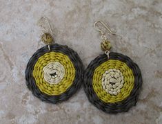 What's brown, yellow, and tan, and groovy all over? Iraca. Fiber. Earrings. With a seed bead nonetheless. Iraca fiber - The discs are hand woven, and no two are exactly the same. Source: Fallen leaves from Iraca palm plants in South America. Color: Brown, yellow, and tan Iraca disc diameter: 1.4 inches (35.56 mm) Earring length: 2 inches (50.8 mm) Ear wire: 14k gold-filled Yellow Round Earrings For Beach, Bohemian Yellow Round Earrings, Yellow Bohemian Round Earrings, Handmade Yellow Circle Earrings, Yellow Earrings For Beach With Pierced Ears, Unique Yellow Summer Earrings, Unique Yellow Earrings For Summer, Yellow Earrings With Ear Wire For Beach, Yellow Earrings For Beach With Ear Wire