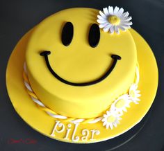 a yellow smiley face cake with white daisies on the top and word plar