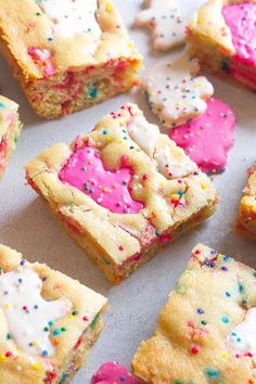 colorful sprinkles and white frosting are on top of square pieces of cake