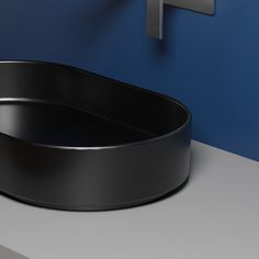 a black round sink sitting next to a blue wall