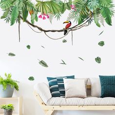 a living room filled with furniture and lots of green leaves on the wall behind it