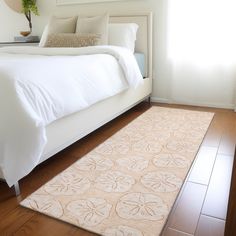 a white bed sitting next to a window in a bedroom on top of a hard wood floor