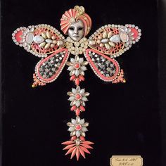 an ornate cross is adorned with jewels and beads on a black velvet background, featuring a woman's face