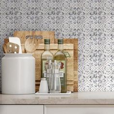 bottles and utensils are sitting on a counter top next to a cutting board