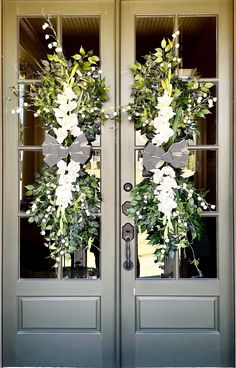 two double doors decorated with wreaths and flowers