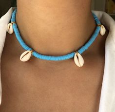 DEEP DIVE (Blue) * Ultimate Modern Boho Summer Necklace * Blue Enamel Coin Beads (6mm) * Natural cowrie shells * Stainless steel chain and carabiner in gold (no fading) * Full chain length: 45cm * Adjustable: yes * Beachworthy * Good vibes only! ➪  𝐴𝑙𝑙 𝑃𝑟𝑜𝑑𝑢𝑐𝑡𝑠 𝑎𝑟𝑒 𝑐𝑎𝑟𝑒𝑓𝑢𝑙𝑙𝑦 𝑝𝑎𝑐𝑘𝑎𝑔𝑒𝑑 𝑤𝑖𝑡ℎ 𝑙𝑜𝑣𝑒.  ➪  𝑃𝑎𝑐𝑘𝑎𝑔𝑒 𝑖𝑛𝑐𝑙𝑢𝑑𝑒𝑠: 𝐼𝑡𝑒𝑚 (𝑜𝑓 𝑐𝑜𝑢𝑟𝑠𝑒), 𝑎 𝑙𝑜𝑣𝑒𝑙𝑦 𝑉𝑒𝑙𝑣𝑒𝑡 𝐺𝑖𝑓𝑡 𝑏𝑎𝑔. ✲ 𝑇ℎ𝑒 𝑟𝑒𝑐𝑜𝑚𝑚𝑒𝑛𝑑𝑒𝑑 𝑐ℎ𝑎𝑖𝑛 𝑠𝑖𝑧𝑒 𝑓? Blue Beaded Beachy Jewelry, Light Blue Beaded Necklaces For The Beach, Blue Strand Necklace With Beachy Style, Light Blue Beaded Necklace For The Beach, Light Blue Beaded Necklace For Beach, Beachy Blue Jewelry With Colorful Beads, Light Blue Round Bead Necklaces For The Beach, Handmade Blue Necklaces For The Beach, Handmade Blue Necklaces For Beach