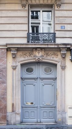 an old building with two blue doors on the front