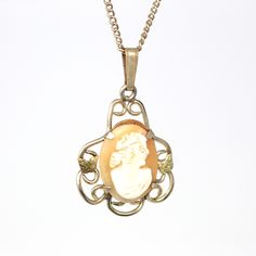 "Classic vintage 1940s retro 12k rose gold filled cameo necklace! This lovely statement pendant depicts a gorgeous woman in white carved shell, with a salmon colored background. The pendant is adorned in scrolled designs with yellow gold filled butterflies on either side of the cameo. The piece hangs from its original matching 18.25 inch 12k rose gold filled chain. A stunning piece of 1940s era jewelry, featuring a beautiful carved cameo! *Sale - price reduced from $120 USD to $110 USD.  ERA - C Classic Cameo Necklace With Oval Pendant, Vintage Rose Gold Filigree Necklaces, Vintage Rose Gold Filigree Necklace, Vintage Cameo Oval Pendant Jewelry, Vintage Oval Cameo Necklace, Vintage Rose Gold Pendant Necklace, Vintage Cameo Necklace For Vintage Events, Antique Cameo Necklace For Vintage Events, Vintage Cameo Necklaces For Vintage Events