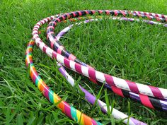 multicolored hula hoop laying in the grass on top of it's side