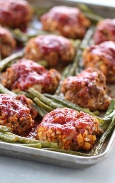 meatballs and green beans in a pan with ketchup on the top, ready to be eaten