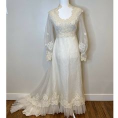 a white wedding dress with long sleeves and lace