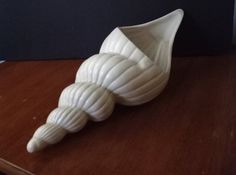 three white vases sitting on top of a wooden table