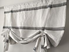 a white curtain with black stripes hanging from it's side