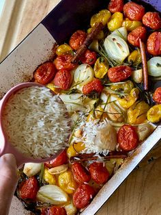 someone is spooning rice into a casserole dish with roasted tomatoes and onions