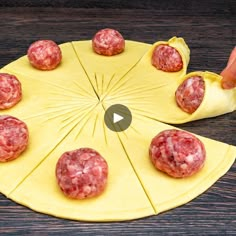 a person placing meatballs on top of a paper plate with a yellow napkin around it