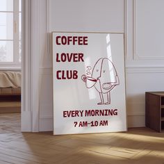 a coffee lover club sign in front of a white room with wood floors and walls