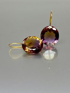 Gorgeous multi-faceted bi-color ametrine earrings from bolivia. The Faceted oval drops are flawless and have a beautiful color blend of purple and yellow. The ametrine drops are attached to 24k vermeil/14K SOLID GOLD ear wires. The earrings are elegant and have a lux look. A truly gorgeous pair of earrings When 14K SOLID GOLD ear wires are being used, the ear wire ends are hand stamped as proof of being 14K solid gold. In addition, extra work was done at the end of the ear wires to prevent any s Chanel Stud Earrings, Pink Topaz Earrings, Citrine Drop Earrings, Ruby Earrings Studs, Tiger Eye Jewelry, Earrings Purple, Solid Gold Earrings, Purple And Yellow, Anniversary Gift For Her