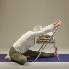 a woman is sitting on the floor doing yoga