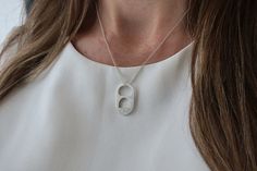 a woman wearing a necklace with the letter c on it