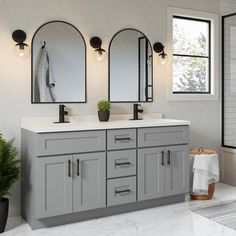 a bathroom with double sinks and mirrors on the wall