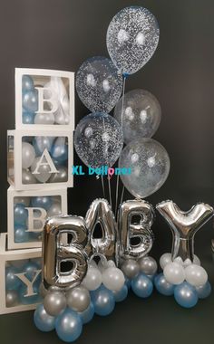 silver and white balloons are in the shape of baby's first birthday letters,