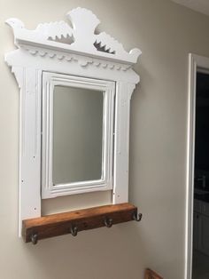 a white mirror mounted to the side of a wall next to a wooden banister