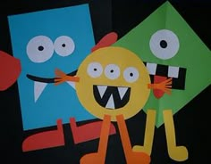 two paper monsters are standing next to each other with their mouths open and eyes wide