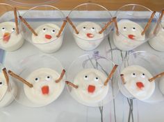 cupcakes with frosting and sticks in the shape of snowmen on them