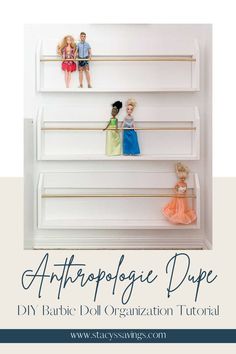 White thin magazine rack style wall racks with a thin gold rod to hold dolls in place standing up. Great use of space to display dolls and keep their hair from getting tangled. Three modern-styled racks hung one above the other on a white wall for maximum Barbie Doll Storage. Storage For Dolls, Organizing Toys In Bedroom, Barbie Doll Wall Storage, Barbie Wall Storage Ideas, Playroom Organization Dolls, Barbie Room Diy, Batbie Storage, Playroom Ideas With Barbie House, Organization For Barbie Stuff