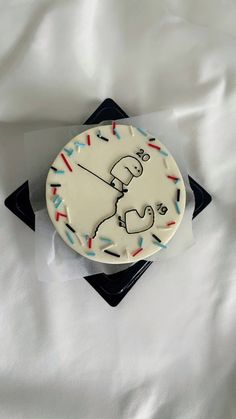 a white cake with sprinkles and a cartoon character on it