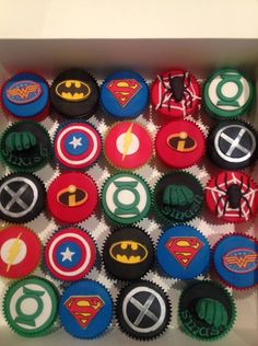 the cupcakes are decorated in different colors and designs, including batman, superman, captain america, green lantern, wonder woman