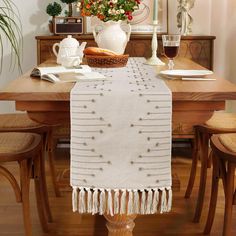 a dining room table with a basket on top of it and flowers in the background